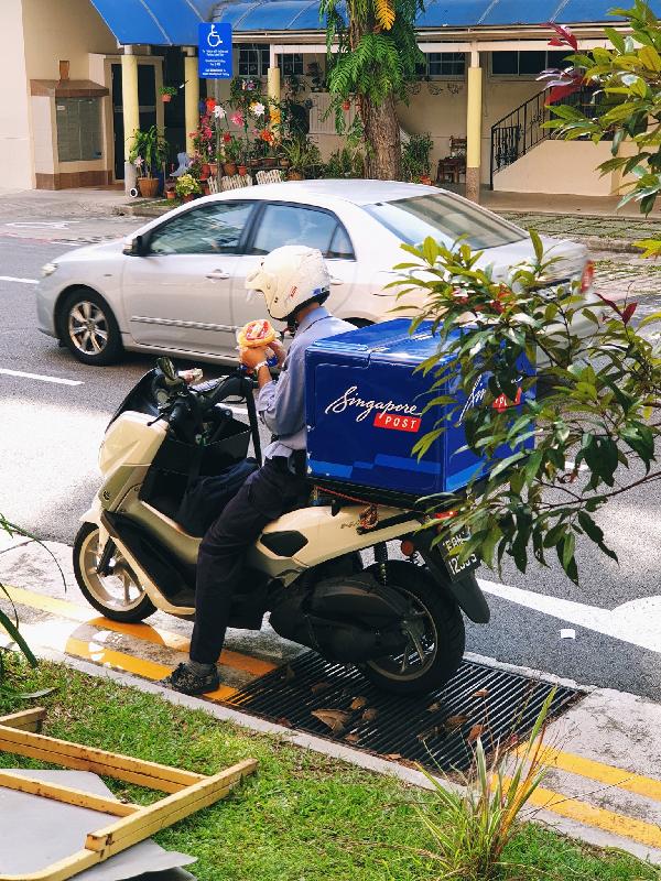 SingPost postman having lunch on his bike evokes sympathy